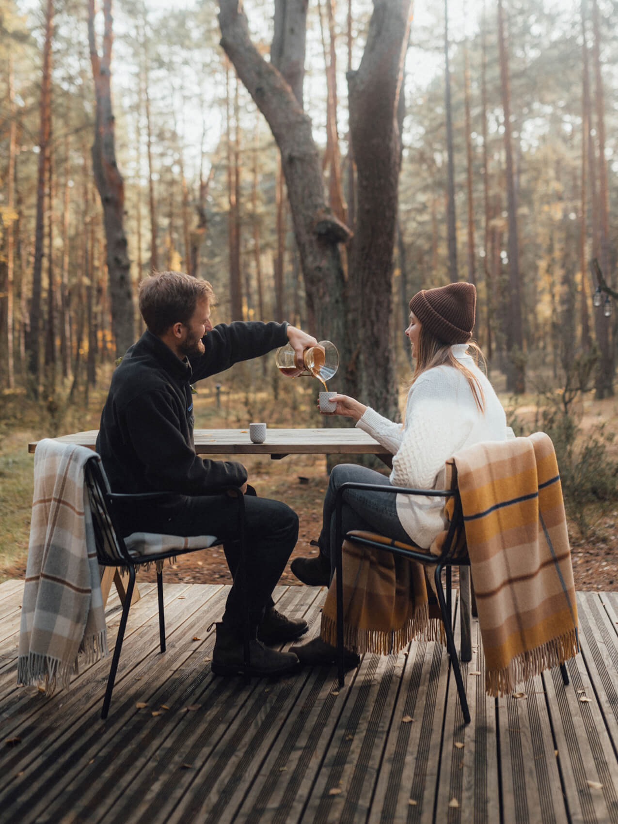 A couple enjoying a refreshing drink amidst the serene beauty of the woods.