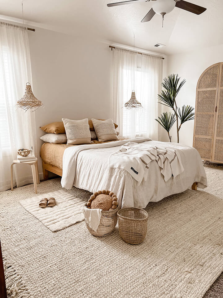 Relaxing bedroom with comfy bed, rug, blanket and fan.