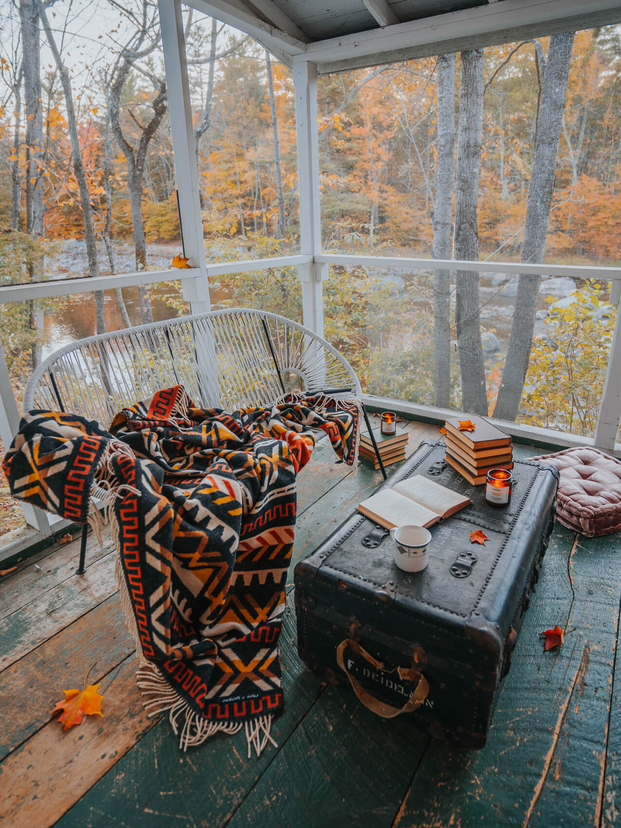 A cozy porch with a table and a blanket, perfect for relaxing outdoors.