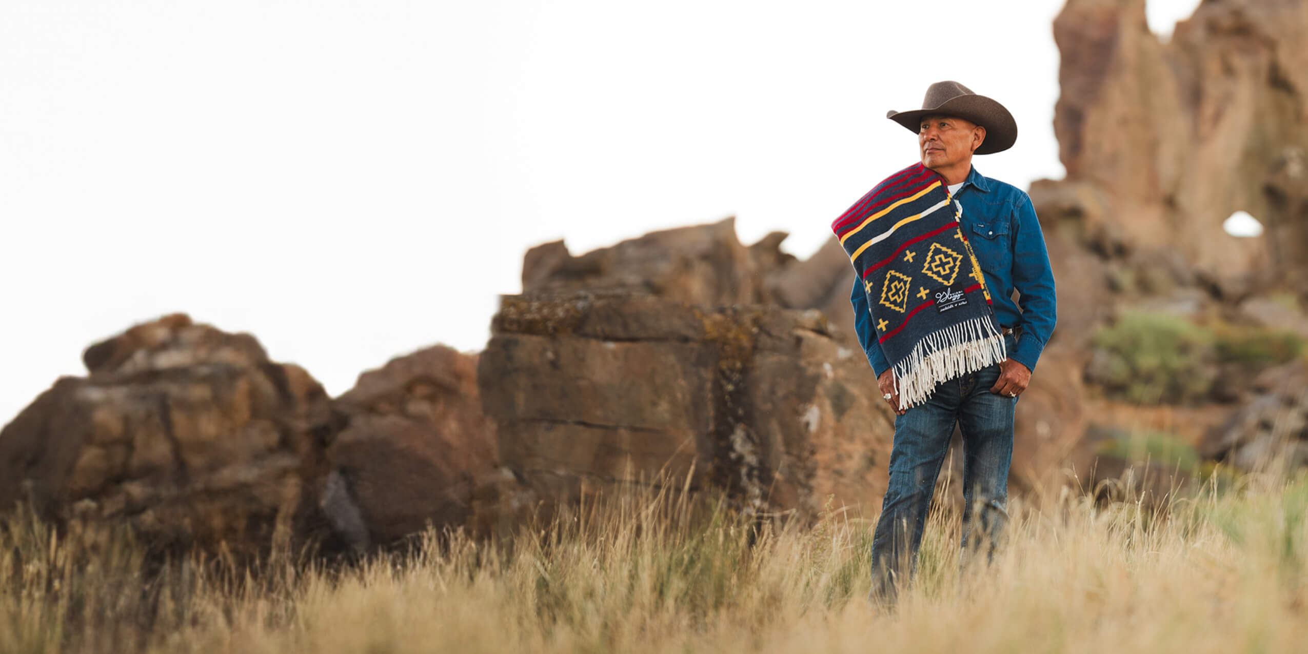 Man in western attire amidst greenery. 