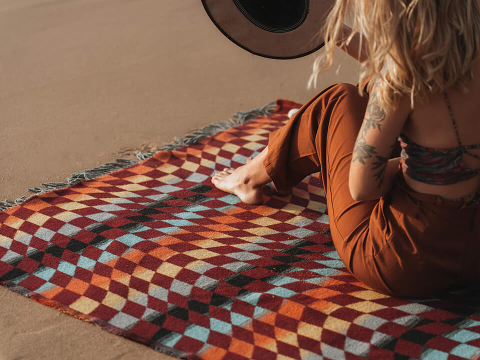 Woman relaxing on blanket with hat. 