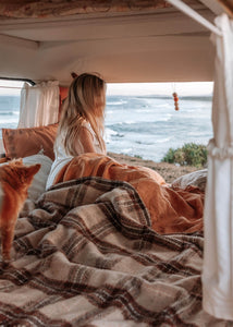 A woman and her dog in a van, with the mesmerizing ocean view behind them.